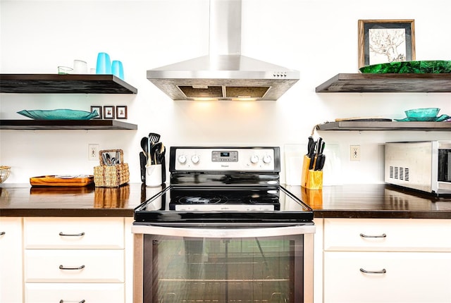 kitchen with white cabinetry, stainless steel electric range, and wall chimney exhaust hood