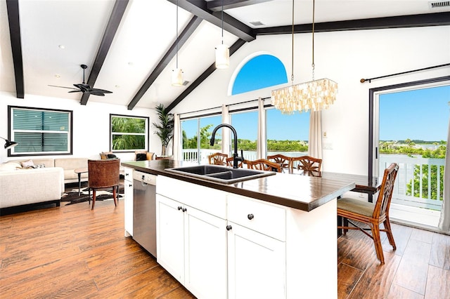 kitchen featuring sink, white cabinetry, hanging light fixtures, dishwasher, and a kitchen island with sink