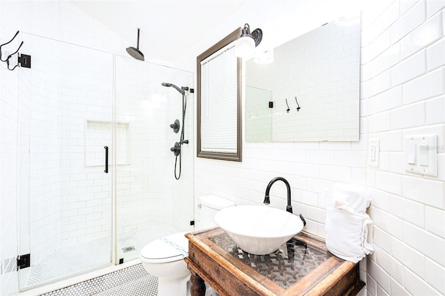 bathroom featuring tile walls, sink, backsplash, and an enclosed shower