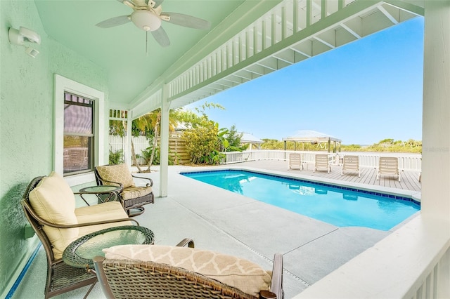 view of swimming pool with ceiling fan and a patio area