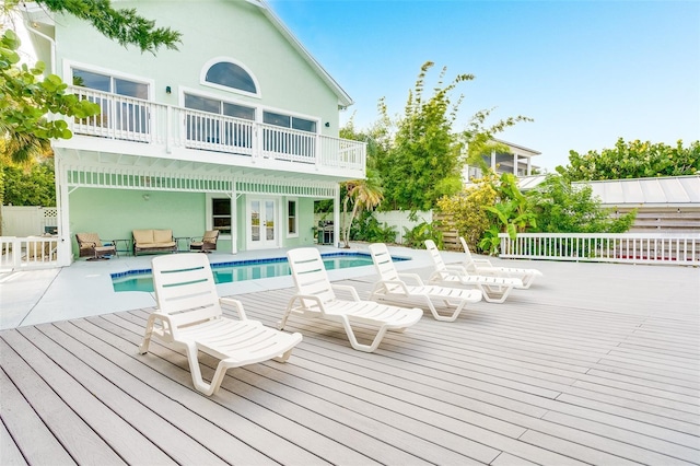 rear view of property featuring a fenced in pool and a patio area