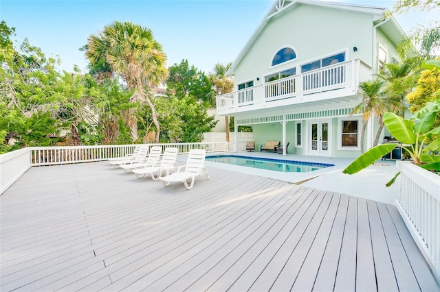 rear view of property with a swimming pool side deck and french doors