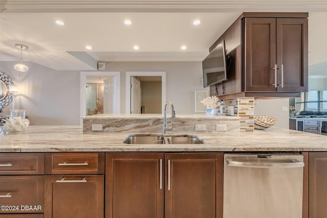 kitchen with light stone counters, dishwasher, sink, and pendant lighting