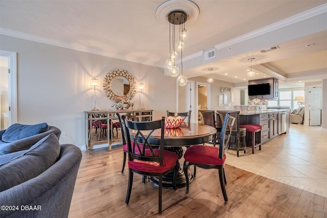 dining area featuring ornamental molding and light hardwood / wood-style floors