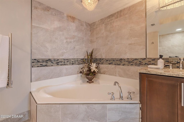 bathroom featuring a relaxing tiled tub and vanity