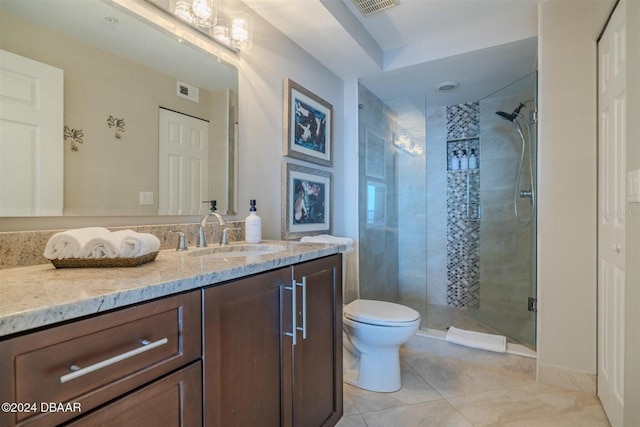 bathroom featuring vanity, toilet, tile patterned floors, and walk in shower