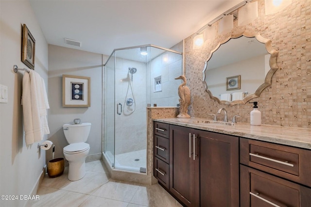 bathroom featuring tasteful backsplash, tile patterned flooring, vanity, an enclosed shower, and toilet