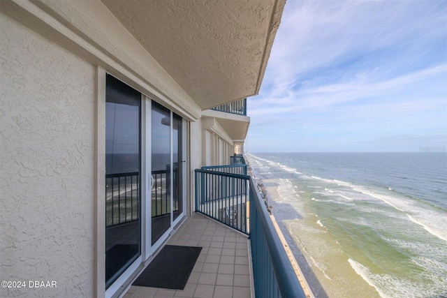 balcony featuring a water view and a beach view