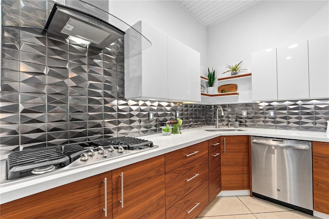 kitchen with stainless steel appliances, sink, light tile patterned floors, and white cabinets