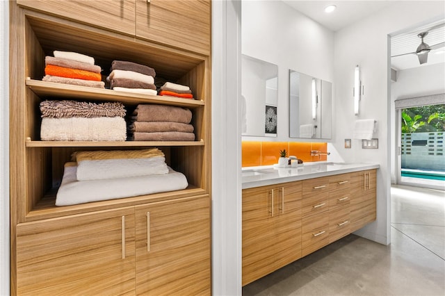 bathroom featuring vanity, concrete flooring, and ceiling fan