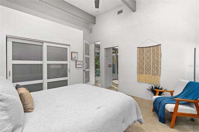 carpeted bedroom with beamed ceiling, ceiling fan, and a towering ceiling