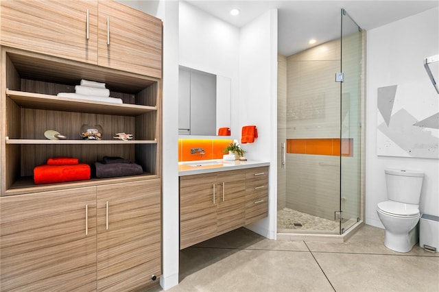 bathroom featuring an enclosed shower, vanity, tile patterned floors, and toilet