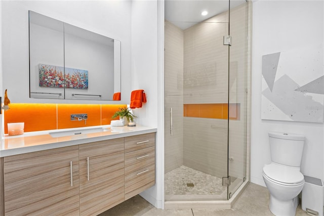 bathroom featuring vanity, an enclosed shower, and toilet