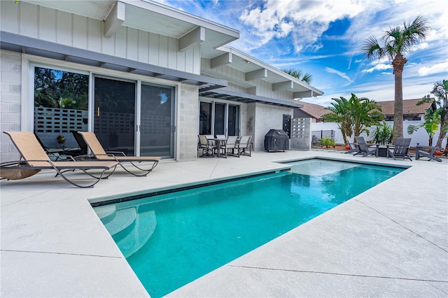 view of pool featuring area for grilling and a patio