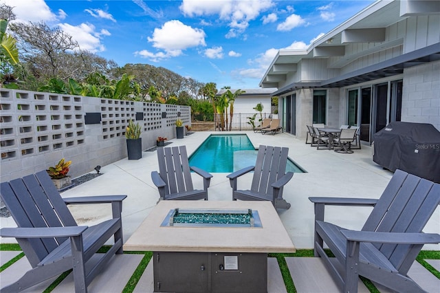 view of pool with grilling area, a patio, and an outdoor fire pit