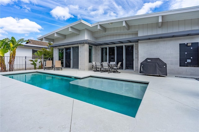 view of pool with grilling area and a patio