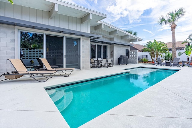 view of swimming pool featuring grilling area and a patio area