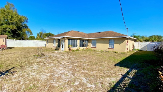 rear view of property with a lawn