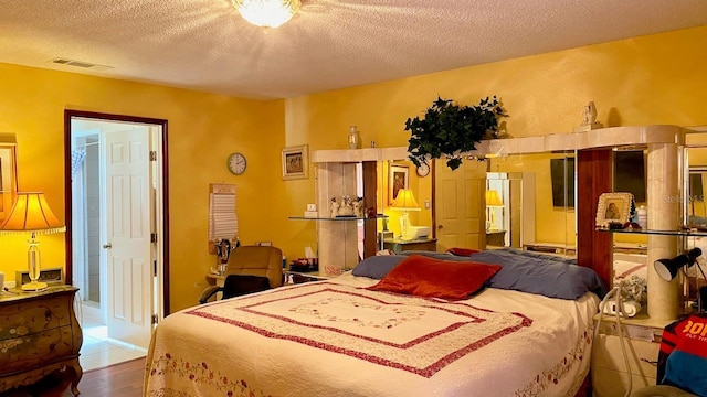 bedroom with wood-type flooring and a textured ceiling