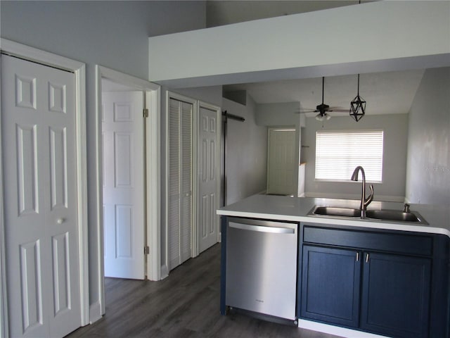 kitchen featuring sink, stainless steel dishwasher, dark wood-type flooring, a barn door, and blue cabinetry