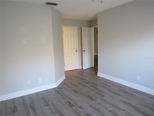 spare room featuring dark wood-type flooring