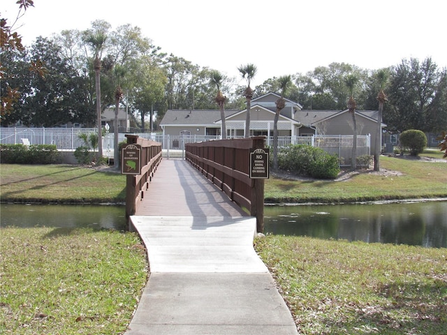 view of dock with a water view and a lawn