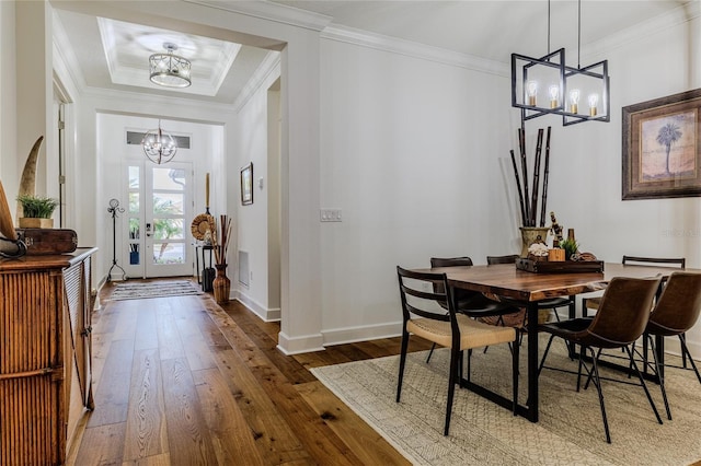 dining room with ornamental molding, dark hardwood / wood-style flooring, and a notable chandelier