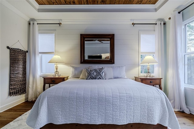 bedroom featuring a raised ceiling, crown molding, and hardwood / wood-style floors