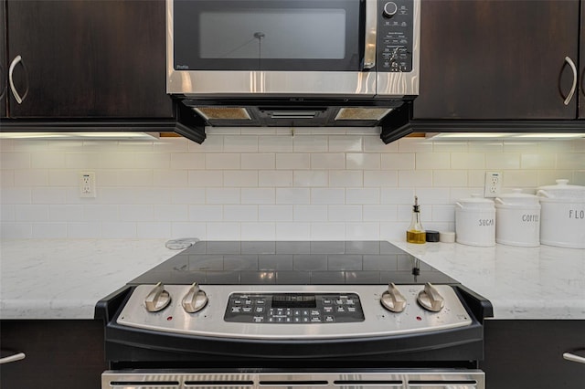 kitchen featuring light stone counters, stainless steel appliances, dark brown cabinets, and backsplash