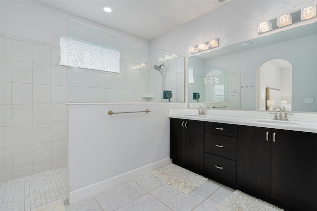 bathroom featuring tile patterned flooring, vanity, and tiled shower