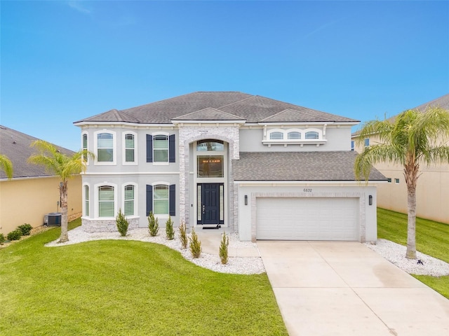 view of front of home featuring a garage, a front lawn, and central air condition unit