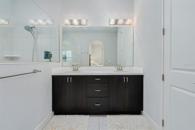 bathroom featuring vanity, tile patterned flooring, and tiled shower