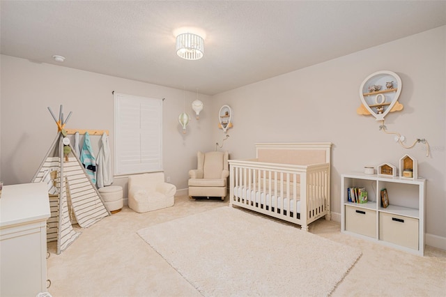 bedroom featuring a nursery area and light colored carpet