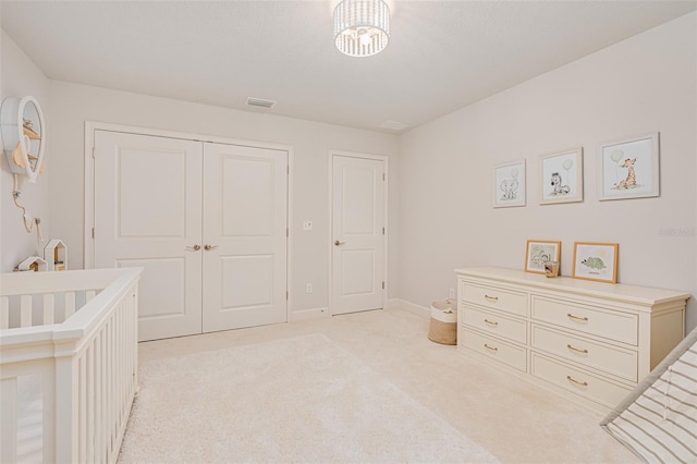 carpeted bedroom with a nursery area and a closet