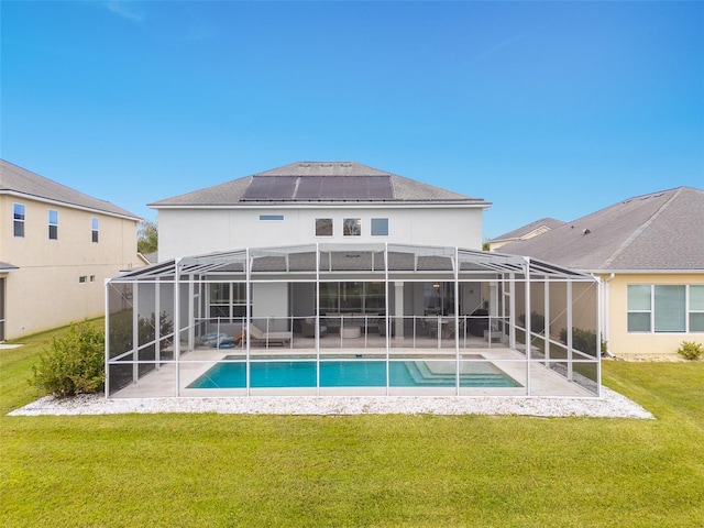 back of property featuring a lawn, a patio, and solar panels