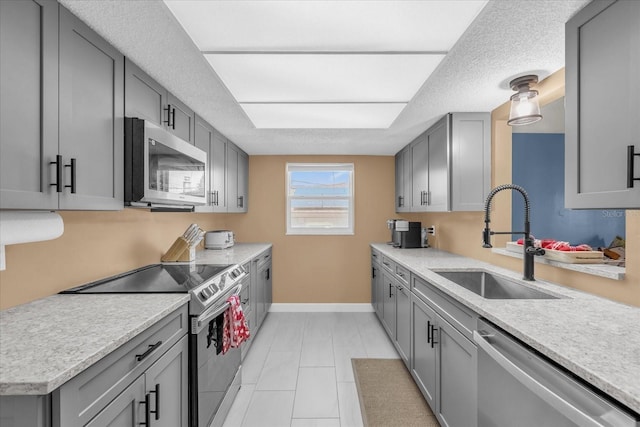 728 Vicksburg St, Deltona, FL 32725 - kitchen with appliances with stainless steel finishes, a sink, gray cabinetry, baseboards, and light countertops