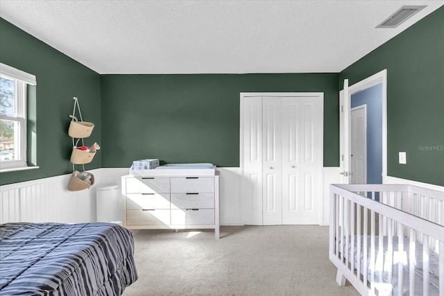 728 Vicksburg St, Deltona, FL 32725 - bedroom with wainscoting, carpet floors, a textured ceiling, a closet, and a nursery area