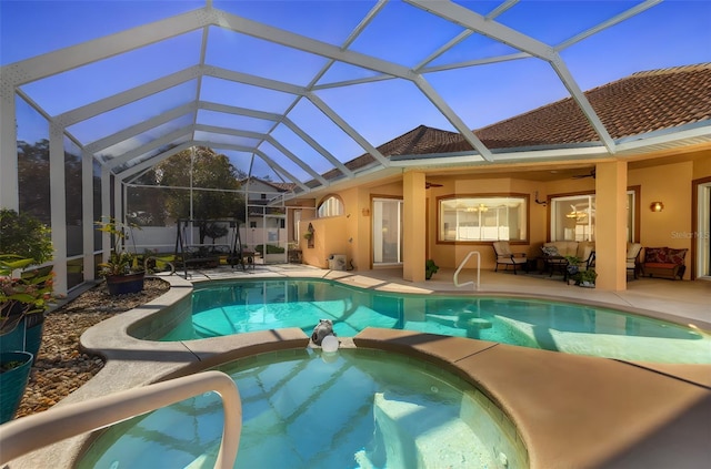 view of pool featuring a patio area, ceiling fan, and glass enclosure