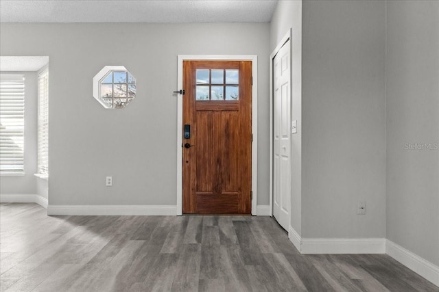 foyer entrance featuring wood-type flooring and a textured ceiling