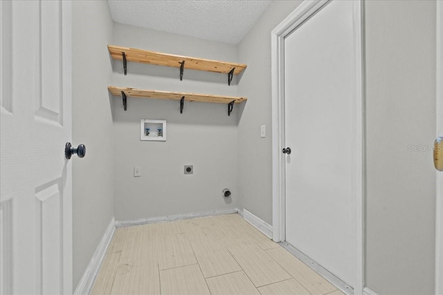 laundry area featuring hookup for an electric dryer, hookup for a washing machine, a textured ceiling, and light hardwood / wood-style flooring