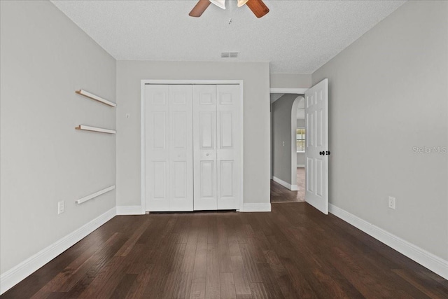 unfurnished bedroom featuring ceiling fan, hardwood / wood-style flooring, a closet, and a textured ceiling