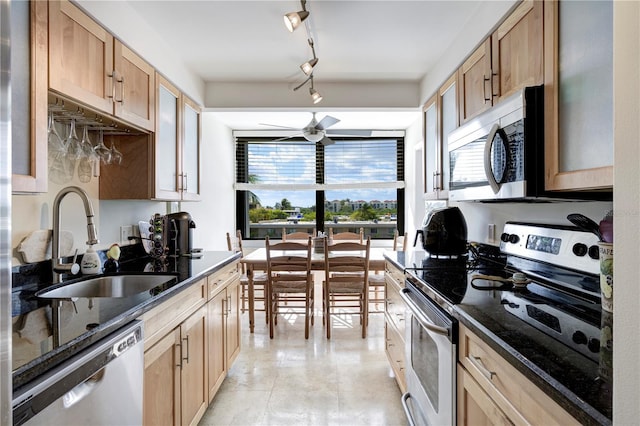 kitchen with appliances with stainless steel finishes, sink, dark stone countertops, ceiling fan, and track lighting