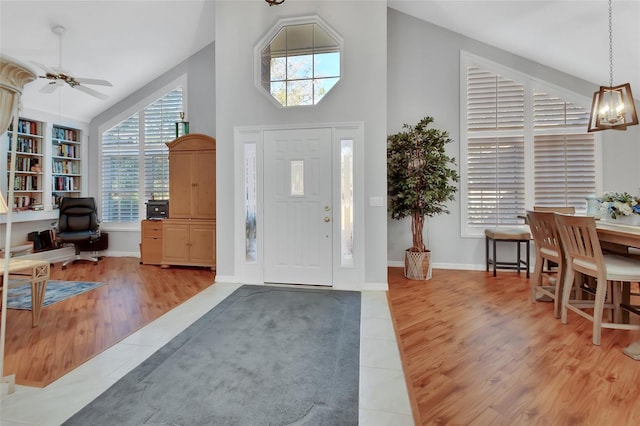 entrance foyer with ceiling fan, high vaulted ceiling, and light hardwood / wood-style flooring