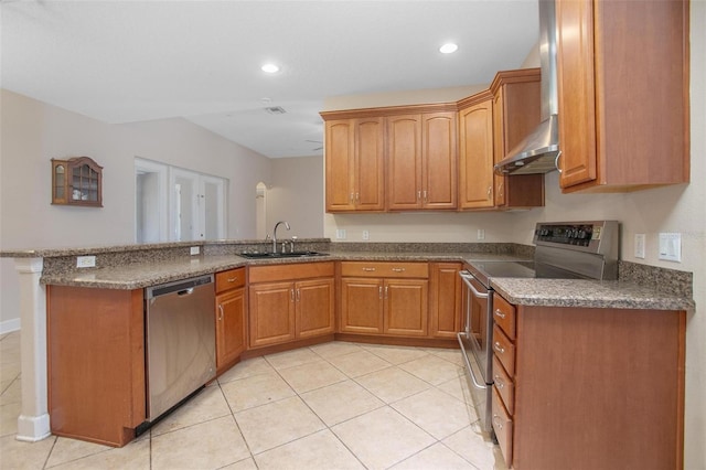 kitchen featuring light tile patterned flooring, sink, appliances with stainless steel finishes, kitchen peninsula, and wall chimney range hood