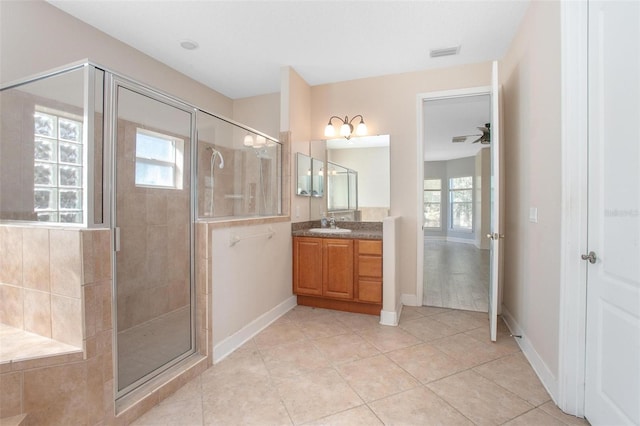 bathroom with walk in shower, plenty of natural light, tile patterned flooring, and vanity