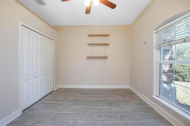 unfurnished bedroom featuring light hardwood / wood-style floors, a closet, and ceiling fan