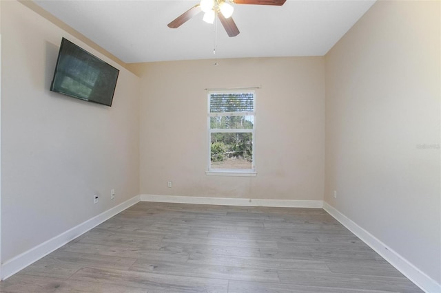 empty room with ceiling fan and light hardwood / wood-style flooring