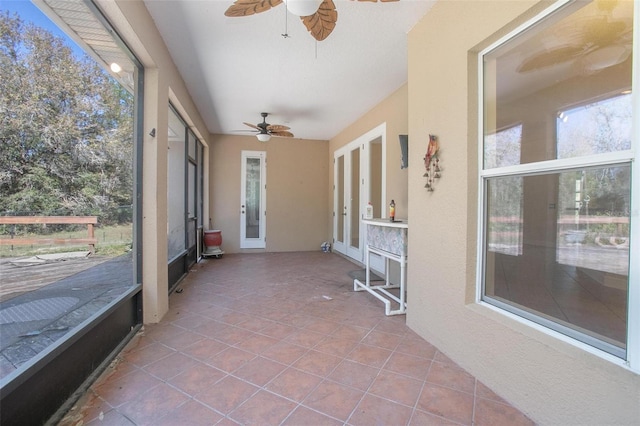 unfurnished sunroom featuring ceiling fan