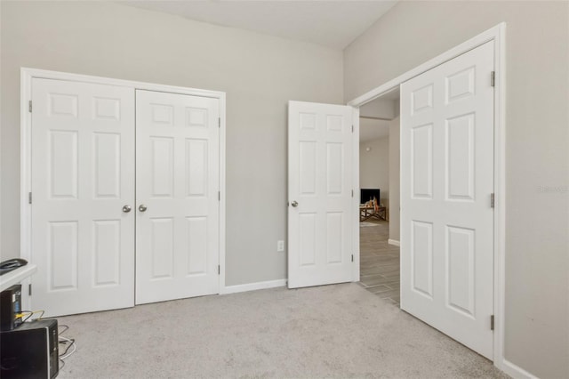 unfurnished bedroom featuring light carpet and a closet