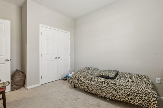 bedroom with light colored carpet and a closet